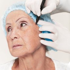 surgeon doing skin check on mid age woman before plastic surgery The surgeon doing skin check on mid age woman before plastic surgery. Senior female model. plastic surgery, lifting, aging concept